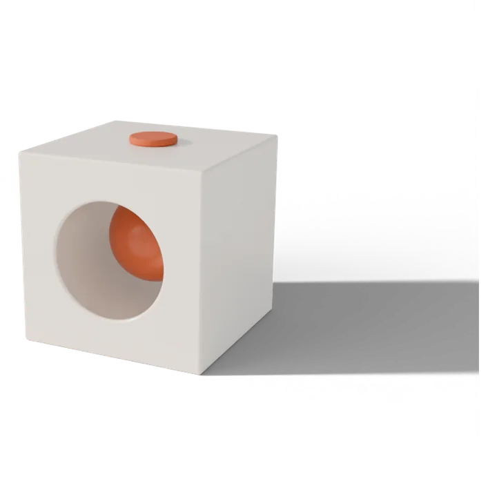 A terracotta ball locked inside a white ceramic block